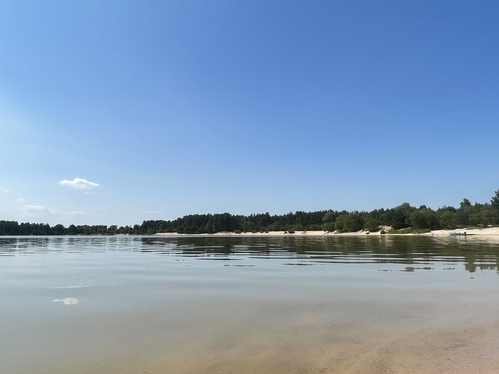 Песчаный пляж и прозрачная вода озера